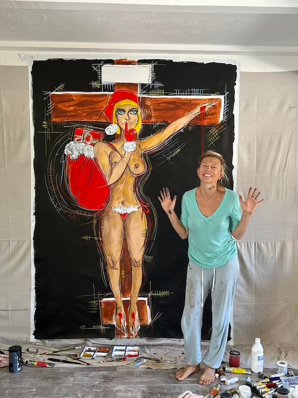 Marina Orlova posing with large figurative painting in studio