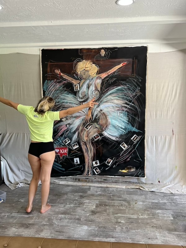Marina Orlova painting large mural indoors in studio