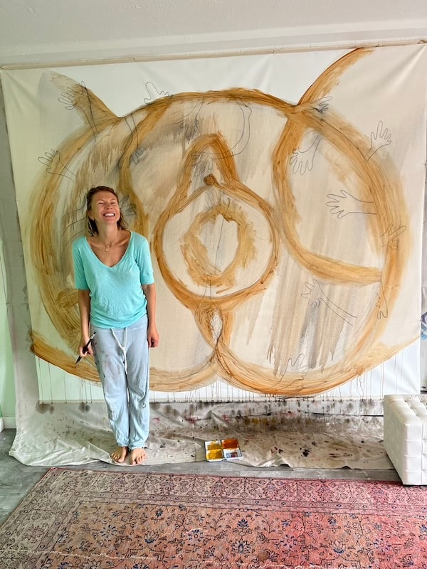 Marina Orlova posing with large abstract cat drawing in studio