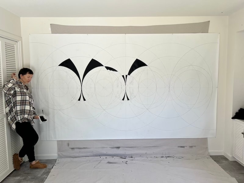 Marina Orlova creating large geometric wall mural in studio